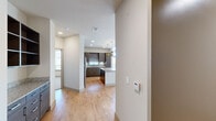 Located at 900 Grange Hall Dr in Euless, TX, this well-appointed 3-bedroom, 3-bathroom single-story residence offers a thoughtfully designed open-concept layout. Light-toned hardwood flooring flows throughout the main living areas, creating a warm and cohesive aesthetic. The kitchen serves as a focal point of the home, showcasing dark espresso cabinetry, a tile backsplash, stainless steel appliances, granite countertops, and a central island illuminated by stylish pendant lighting — ideal for both cooking and entertaining. The living area benefits from abundant natural light, with oversized sliding glass doors leading to a private balcony that offers open outdoor views. The primary bedroom features soaring ceilings with transom windows, plush carpeting, and a generous closet. Additional bedrooms are well-sized and versatile. The bathrooms are finished with granite-topped vanities, undermount sinks, and tile flooring, reflecting consistent quality throughout. A dedicated laundry area with a full-size washer and dryer adds everyday convenience. Walk-in closets provide ample storage. The overall ambiance is clean, contemporary, and functional, making this residence a comfortable and stylish home in the heart of the DFW Metroplex.