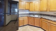 Located at 3 Lilac Ave in Fox Lake, IL, this single-floor, one-bedroom, one-bathroom unit offers a compact and efficiently designed living space. The layout features a clear separation between living and functional areas, connected by a carpeted hallway with a distinctive built-in wood shelving unit that provides an open pass-through view into the kitchen, adding a touch of character to the interior.

The kitchen is equipped with warm oak cabinetry offering ample upper and lower storage, granite-patterned countertops, a double stainless steel sink, a black electric range with overhead exhaust, and a full-size refrigerator. A skylight panel in the drop ceiling brings additional brightness to the space. Tile flooring throughout the kitchen provides easy maintenance.

The bedroom is a generously proportioned room featuring soft carpet flooring, neutral walls, a multi-pane window that invites natural light, and baseboard heating. A built-in closet with sliding doors and overhead shelving provides practical storage solutions.

The bathroom is thoughtfully equipped with a full-size soaking tub and shower combination, accented by safety grab bars, a wall-mounted sink, and tile flooring, making it both functional and accessible.

Overall, the unit presents a clean, practical interior with warm wood accents, consistent neutral tones, and functional finishes throughout.