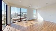 Located at 2922 W Marshall St in Richmond, VA, this contemporary 2-bedroom, 1-bathroom unit offers a well-designed, single-floor layout that maximizes both function and style. The open-concept living and kitchen area is a standout, anchored by dramatic floor-to-ceiling grid-pane windows that flood the space with natural light and frame impressive elevated views of the surrounding Richmond cityscape. Warm hardwood-style flooring runs throughout, complementing the clean white walls and modern finishes.

The kitchen is outfitted with white cabinetry, open shelving, stainless steel appliances including a refrigerator, range, microwave, and dishwasher, as well as a sleek countertop with an undermount sink. The living area benefits from the expansive glazing, creating a bright and airy atmosphere.

Both bedrooms are comfortably sized, featuring hardwood-style floors, neutral walls, and ample natural light. The primary bedroom offers generous closet space, with dual closet doors providing convenient storage. A dedicated walk-in closet fitted with full wire shelving and hanging rods adds practical organization. The bathroom features large-format tile flooring, a wood-toned vanity with a white countertop, and clean, minimal finishes throughout.