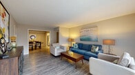 This single-floor residence in Lyndon, Kentucky, offers a well-designed layout that balances open communal spaces with comfortable private retreats. The living room serves as the heart of the home, featuring wood-look flooring, a large sliding glass door that invites natural light, and an open sightline into the dining area, creating a seamless flow ideal for everyday living and entertaining. The dining room is generously sized, accommodating a full dining table with ease, and connects directly to the kitchen. The kitchen is well-appointed with white shaker-style cabinetry, dark countertops, a subway tile backsplash, and a full suite of stainless steel appliances including a dishwasher and range with overhead ventilation. The bedrooms are carpeted for comfort and each includes a ceiling fan with light. The primary bedroom is spacious with room for a full dresser and ample closet storage. A bathroom with a white vanity and pendant lighting serves the bedroom wing. Throughout the home, neutral tones and clean finishes create a bright, cohesive aesthetic, while the practical single-floor layout ensures convenient accessibility across all rooms.