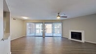 This single-story, 3-bedroom, 2-bathroom home offers a practical and comfortable layout across a well-utilized floor plan. The combined kitchen and living area serves as the heart of the home, where the living room impresses with wide sliding glass doors dressed in vertical blinds that flood the space with natural light and provide outdoor views. A ceiling fan with light fixture keeps the area comfortable, while a classic fireplace with a white tile surround adds a welcoming focal point. Hardwood-style flooring runs consistently throughout the main living areas, lending a clean and cohesive aesthetic.

The kitchen is efficiently designed with dark espresso cabinetry, light countertops, and black appliances including a dishwasher, range, and refrigerator. A window above the sink brings in additional natural light.

The primary bedroom is a generously sized retreat, featuring a walk-in closet with built-in shelving for ample storage. The secondary bedrooms are well-proportioned, each with hardwood-style flooring, ceiling fans, and closets. One bedroom features a sliding glass door with exterior access. The two bathrooms are clean and functional, each featuring a tub-shower combination, dark vanity cabinetry, and light countertops. A hallway connects all rooms, completing this efficient and livable home.