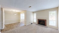 Located at 6300 Moseley Dixon Rd in Macon, Georgia, this single-story, 2-bedroom, 1-bathroom home offers a comfortable and functional layout. The living room serves as the heart of the home, anchored by a classic brick fireplace flanked by two tall windows that flood the carpeted space with natural light, creating a warm and inviting atmosphere. The kitchen features white cabinetry with decorative paneling, light wood countertops, durable wood-look flooring, and black appliances including a range, microwave, and refrigerator — a practical and clean setup for everyday cooking. A pantry provides additional storage to keep the kitchen organized. The primary bedroom is generously sized and includes a ceiling fan, two windows for ample natural light, and direct access to a dedicated walk-in closet with built-in shelving and hanging rods. The second bedroom also features carpet flooring, a ceiling fan, and a sliding glass door with vertical blinds leading to an outdoor area, offering greenery views. The full bathroom is efficiently appointed with a tub/shower combo and wood-look flooring. A dedicated closet adds to the home's overall storage. The single-floor layout ensures easy accessibility throughout, making this a well-rounded and practical residence.