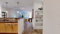 This thoughtfully designed 2-bedroom, 2-bathroom residence offers a comfortable and functional single-floor layout. The open-concept living, dining, and kitchen area serves as the heart of the home, with warm hardwood-style flooring flowing seamlessly from the dining space into the living room. The living room features crown molding, a neutral color palette, and French doors that invite abundant natural light and views of the outdoors. A built-in shelving unit adds a stylish and practical touch to the main hallway.

The galley-style kitchen is efficiently laid out with light maple cabinetry, dark granite countertops, a tile backsplash, stainless steel appliances, and tile flooring. A peninsula counter connects the kitchen to the dining area, enhancing the open feel of the space.

The primary bedroom is a well-sized retreat with dual windows overlooking greenery, providing a bright and tranquil atmosphere. A spacious walk-in closet with wire shelving offers ample storage. Both bathrooms feature tile flooring, with one including a tub-shower combination.

Additional highlights include a dedicated in-unit laundry room equipped with a full-size washer and dryer, and a second closet for added storage. The residence combines practical living with warm, inviting design details throughout.