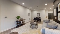 This well-appointed single-floor residence offers a seamless blend of modern design and functional living. The open-concept living and dining area features wood-look flooring, recessed lighting, and a ceiling fan, with large sliding glass doors that frame serene wooded views and flood the space with natural light. The adjoining kitchen is a standout, showcasing gray shaker cabinetry, dark granite countertops, a textured tile backsplash, stainless steel appliances including a double oven and French door refrigerator, and a curved island with pendant lighting — ideal for casual dining and entertaining. The bedrooms offer plush carpeting, neutral tones, and black-framed windows that provide a contemporary touch. A dedicated office space features patterned wallcovering, carpet, and ample natural light, making it well-suited for remote work or study. The bathrooms are finished to a high standard, with one featuring a dual-sink vanity with rich wood cabinetry and a stacked stone accent wall, and another offering a walk-in glass shower, herringbone tile flooring, and a light gray vanity with brushed nickel fixtures. Throughout the residence, a cohesive neutral palette, quality materials, and thoughtful finishes create a polished and inviting atmosphere.