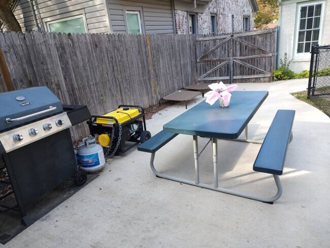 Backyard driveway with grill, picnic table, and ramp to back door - 2816 Alden Ave