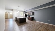 Located in the heart of Columbus, OH, this well-appointed two-story home offers 2 bedrooms, 3 bathrooms, and a thoughtfully designed layout spread evenly across two floors. The main level welcomes you with a bright, open-concept living, dining, and kitchen area anchored by rich hardwood-style flooring and ceiling fans. The modern kitchen is a standout feature, boasting dark espresso cabinetry, granite countertops, stainless steel appliances, a large center island with a sink, and stylish pendant lighting. A hallway leads to additional rooms, including a dedicated office and a full bathroom with dark wood vanity, granite countertops, and a tiled shower. The upper floor hosts both bedrooms, including a generously sized primary bedroom with dual windows offering urban Columbus skyline views and plush carpeting underfoot. The second bedroom also features carpeted floors and ample closet storage. Three full bathrooms are finished consistently with granite vanities and hardwood-style tile floors. Additional conveniences include a laundry room, utility room, and multiple closets. A carpeted staircase connects both levels, completing this functional and contemporary home.