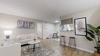 Located at 7703 Seton Lake Dr in Houston, TX, this one-bedroom, one-bathroom residence offers a thoughtfully designed single-floor layout with a cohesive, modern aesthetic. Wood-look flooring runs throughout the space, providing a warm and consistent foundation across every room.

The open living area is bright and welcoming, featuring neutral gray walls, ample natural light from large windows with vertical blinds, and enough room for a full sofa arrangement alongside a dining set. A pass-through counter with bar stools connects the living and dining area to the kitchen, enhancing the open feel.

The galley-style kitchen is efficiently organized, featuring granite-look countertops, gray cabinetry, black appliances including a refrigerator, electric range, and dishwasher, along with a range hood overhead.

The bedroom is a comfortable retreat with a ceiling fan, a large window allowing natural light, and wood-look flooring. It is accompanied by a dedicated walk-in closet with built-in wire shelving for organized storage.

The bathroom is clean and functional, offering a full tub-shower combination with white tile surround, granite-look countertop vanity, and matching fixtures throughout.

The overall ambiance is modern and neutral, making this a practical and stylish Houston residence.