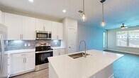 Located at 12400 Dutton Road in Midlothian, VA, this well-appointed one-bedroom, one-bathroom unit offers a thoughtfully designed single-floor layout. The open-concept kitchen is a standout feature, showcasing crisp white shaker cabinetry, a gray subway tile backsplash, and a large quartz-topped center island with an undermount sink and brushed gold faucet. Stainless steel appliances — including a refrigerator with ice maker, electric range, microwave, and dishwasher — complete the kitchen. Globe pendant lights with gold accents hang above the island, adding a modern touch. The kitchen flows seamlessly into the living area, which features wood-look flooring, a ceiling fan, and windows that invite natural light and neighborhood views. The bedroom is carpeted and generously sized, with a ceiling fan and a window overlooking the surrounding community. It connects directly to the bathroom, which features a white vanity with quartz countertop, an undermount sink, brushed nickel fixtures, and a large mirror. A walk-in closet is accessible from the bathroom. A hallway connects the main living spaces, and wood-look flooring runs throughout the non-carpeted areas, tying the unit's clean, contemporary aesthetic together.