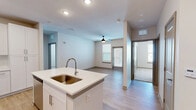 Located at 4101 William Turner Pkwy in Nashville, TN, this well-appointed 2-bedroom, 3-bathroom residence offers a thoughtfully designed single-floor layout. The modern kitchen serves as a central hub, showcasing crisp white cabinetry, quartz countertops, a large island with an undermount sink, stainless steel appliances including a refrigerator, range, and microwave, and a subway tile backsplash. Light wood-style flooring flows through the main living and kitchen areas, creating a bright, cohesive aesthetic. Both bedrooms are carpeted and equipped with ceiling fans, offering a comfortable retreat. The generously sized primary bedroom includes a dedicated closet with wire shelving systems and an en-suite bathroom featuring a dual-sink vanity with white cabinetry and a walk-in shower. An additional full bathroom offers a tiled soaking tub and shower combination. A third bathroom features wood-look flooring and a single vanity. The walk-in closet provides ample storage with multi-level wire shelving. A private balcony extends the living space outdoors. The overall design is clean and contemporary, with neutral tones throughout that create a bright and welcoming atmosphere.