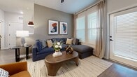This well-designed 920-square-foot, single-floor apartment in Apopka, FL offers 2 bedrooms and 2 bathrooms across a thoughtfully laid-out floor plan. The kitchen is a standout feature, boasting white upper cabinetry, gray lower cabinets, herringbone tile backsplash, stainless steel appliances, and a central island with white quartz countertops illuminated by pendant lighting — ideal for both cooking and casual dining. Wood-look flooring flows throughout the home, adding warmth and continuity. The living room is bright and inviting, featuring large windows with natural light, a sliding door to the outdoors, and neutral tones that create a relaxed atmosphere. The primary bedroom spans 160 square feet and features a bold navy accent wall, large windows, a ceiling fan, and ample closet space. The second bedroom is equally comfortable, with generous natural light and closet access. Both bathrooms are finished with gray cabinetry, white quartz countertops, black hardware, wide vanity mirrors, and wood-look flooring. The hallway connects the rooms efficiently, and two dedicated closets provide practical storage. This apartment combines modern design with functional living in a clean, contemporary aesthetic.