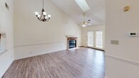 Located at 9001A NW Creekside Ln in Knoxville, Tennessee, this two-story home offers a well-designed layout spread across two floors. The welcoming entrance features parquet hardwood flooring, a decorative arched doorway, and a chandelier overhead, with a carpeted staircase accented by a warm wood banister leading to the upper level.

The main living area impresses with soaring vaulted ceilings, a skylight, and a classic brick fireplace as the focal point. Hardwood-style flooring, a ceiling fan, and French doors that invite natural light complete the space. The kitchen is well-equipped with warm oak cabinetry, granite-look countertops, stainless steel appliances including a refrigerator, dishwasher, and range, plus a skylight that brightens the room.

The spacious primary bedroom includes hardwood-style floors, a ceiling fan, a walk-in closet, and an en-suite bathroom featuring a jetted soaking tub beneath a window. Additional bedrooms are carpeted and include closet space. The upper floor offers a cozy bedroom with plush carpet and a built-in closet.

An attached garage with an automatic opener provides convenient parking and storage. Throughout the home, neutral tones and classic architectural details create a comfortable, functional living environment.