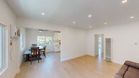 This well-appointed single-floor residence offers a clean, modern aesthetic defined by crisp white walls, light hardwood flooring, and an abundance of natural light throughout. The open-concept living and dining area flows seamlessly, creating a spacious and airy feel ideal for both everyday living and entertaining. Recessed lighting and a ceiling fan enhance the living space's comfort and functionality.

The kitchen is a standout feature, outfitted with white shaker cabinetry, sleek marble-style quartz countertops, a white subway tile backsplash, and a full suite of stainless steel appliances including a gas range, microwave, refrigerator, and dishwasher. A stainless steel undermount sink completes the well-designed workspace.

The dining area is bathed in natural light from multiple windows framing lush outdoor greenery, adding a serene, garden-like atmosphere to mealtimes. A ceiling fan overhead adds to the relaxed ambiance.

The generously sized bedroom features dual mirrored sliding-door closets offering ample storage, a ceiling fan, and sliding glass doors that open directly to a private balcony with pleasant neighborhood views. A bathroom with a white vanity and clean finishes completes the layout. Throughout, the residence maintains a cohesive, contemporary design that feels fresh and move-in ready.