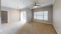 Located at 12035 Huffmeister Rd in Cypress, TX, this single-floor residence offers two bedrooms and three full bathrooms with a functional, well-designed layout. The kitchen is outfitted with dark espresso cabinetry, granite-style countertops, a mosaic tile backsplash, and black appliances including a refrigerator, range, and over-the-range microwave, all set on wood-look flooring. The living area features plush carpeting, crown molding, a ceiling fan, and generous natural light from large windows and a sliding glass door. Each bedroom is carpeted and equipped with a ceiling fan, closet space, and windows with blinds that allow ample natural light. The primary bedroom connects to a private en-suite bathroom. All three bathrooms are finished with dark vanity cabinetry, granite-style countertops, and wood-look tile flooring. The bathrooms include a combination tub/shower as well as a stand-up shower. Neutral gray tones carry throughout the home, lending a cohesive and modern aesthetic. A connecting hallway links the bedrooms and bathrooms, contributing to a practical and efficient floor plan.