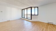 Located at 320 Colborne St in London, Ontario, this 2-bedroom, 1-bathroom unit offers a clean, modern aesthetic throughout. Light wood laminate flooring runs continuously across all living areas, complemented by crisp white walls and textured ceilings that give the space a bright, fresh feel. The entrance leads into an open-concept layout connecting the living room, dining area, and kitchen. The living room is generously sized, highlighted by a striking floor-to-ceiling glass sliding door that opens onto a private balcony, flooding the space with natural light and offering expansive city views. The kitchen is well-equipped with white shaker cabinetry, dark countertops, white subway tile backsplash, and a full suite of stainless steel appliances including a refrigerator, stove, dishwasher, and built-in microwave. The primary bedroom is spacious and features a closet, while the second bedroom offers its own closet and convenient access to the shared bathroom. The bathroom is finished with classic white subway tile surrounding a full soaker tub. A dedicated laundry room houses a stacked washer and dryer unit alongside an in-unit water heater. Three closets throughout provide ample storage for everyday living.