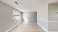 Located at 352 Fox Trace in Augusta, Georgia, this single-story, one-bedroom, one-bathroom unit offers a efficiently designed layout across a compact but functional footprint. The interior features a consistent palette of neutral gray walls, crisp white trim and baseboards, and light-toned luxury vinyl plank flooring that runs throughout, lending a cohesive and clean aesthetic to the entire space.

The combined kitchen and living area forms the heart of the unit. The kitchen is equipped with stainless steel appliances, including an electric range, over-the-range microwave, and refrigerator, complemented by gray upper cabinetry and a window above the sink that brings in natural light. A separate exterior door in the kitchen provides additional access to the unit.

The living area is open and simply appointed, with textured walls, a textured ceiling, and a window fitted with horizontal blinds that allow ample daylight to filter in. The bedroom is a well-defined, cozy space featuring a window, textured walls, and two doors—one providing closet access. The bathroom includes a full tub-shower combination with tile surround, a window for ventilation, and standard fixtures throughout.