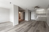 Located at 1371 Parkside Dr in San Bernardino, California, this single-floor unit offers a clean, functional layout with a cohesive design throughout. Warm-toned hardwood-style flooring flows seamlessly across all rooms, creating a unified and inviting atmosphere.

The open living area is bright and airy, featuring a ceiling fan with a light fixture and a sliding glass door that allows natural light to pour in while offering a view to the outdoors. The kitchen is efficiently designed with light-colored cabinetry, a countertop with an integrated sink, and a dishwasher, making it practical for everyday use.

The bedroom is a comfortable, well-proportioned room with a window fitted with blinds that brings in natural light while maintaining privacy. A wall-mounted air conditioning unit provides individual climate control. The textured ceiling is consistent throughout the unit, adding a classic finish.

The bathroom is notably accessible, featuring sturdy grab bars near the bathtub/shower combo and toilet area. It includes a vanity with storage cabinets below, dual medicine cabinet mirrors, and continues the warm hardwood-style flooring seen throughout the unit. The overall design of the space is practical, well-maintained, and move-in ready.