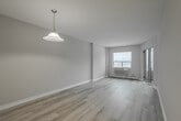 Located at 425 Sugarcreek Tr in London, Ontario, this well-appointed one-bedroom, one-bathroom unit offers a practical and comfortable layout across a single floor. The entryway, finished with light tile flooring, opens to a welcoming hallway that connects the main living spaces. The galley-style kitchen features white cabinetry, dark countertops, white appliances including a stove, microwave, and refrigerator, and tile flooring — with a pass-through breakfast bar that connects seamlessly to the dining and living area. The combined dining and living room is generously proportioned, bathed in natural light from a large window and sliding glass door that leads to a private balcony with outdoor views. Light laminate hardwood flooring runs throughout the living areas, adding warmth and continuity. The bedroom is a comfortable size, featuring its own window with natural light, a closet, and the same laminate flooring. The full bathroom is finished with tile flooring, a white vanity with single sink, and a tiled tub-shower combination. The overall palette of soft neutral tones, white trim, and clean finishes gives the unit a bright, modern, and move-in-ready ambiance.