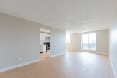 Located at 37 Vanier Dr in Kitchener, Ontario, this 2-bedroom, 1-bathroom unit offers a well-organized and efficiently designed layout spread across a single floor. Light wood laminate flooring flows consistently throughout the main living areas, complementing the neutral grey and white wall tones to create a clean, bright aesthetic.

The open-concept kitchen and living area form the heart of the unit. The kitchen is outfitted with white cabinetry reaching toward the ceiling, a stainless steel electric range, a stainless steel sink, grey countertops, and a peninsula counter that separates it from the living space. The spacious living room benefits from large sliding glass doors and multiple windows, allowing abundant natural light and outdoor views.

The primary bedroom is a generous size, featuring light wood flooring, a window with natural light, and a closet with a hanging rod. The second bedroom is compact and functional, highlighted by a built-in shelving unit beneath a window offering exterior views — a practical and unique storage feature. A dedicated closet provides additional storage within the unit.

The bathroom is finished with large-format tile flooring, a white vanity with a countertop sink, a mirrored medicine cabinet, and a combined tub and shower area. Textured ceilings are found in select areas of the unit, adding a classic residential character throughout.