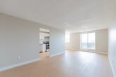 Located at 37 Vanier Dr in Kitchener, Ontario, this 2-bedroom, 1-bathroom unit offers a well-organized and efficiently designed layout spread across a single floor. Light wood laminate flooring flows consistently throughout the main living areas, complementing the neutral grey and white wall tones to create a clean, bright aesthetic.

The open-concept kitchen and living area form the heart of the unit. The kitchen is outfitted with white cabinetry reaching toward the ceiling, a stainless steel electric range, a stainless steel sink, grey countertops, and a peninsula counter that separates it from the living space. The spacious living room benefits from large sliding glass doors and multiple windows, allowing abundant natural light and outdoor views.

The primary bedroom is a generous size, featuring light wood flooring, a window with natural light, and a closet with a hanging rod. The second bedroom is compact and functional, highlighted by a built-in shelving unit beneath a window offering exterior views — a practical and unique storage feature. A dedicated closet provides additional storage within the unit.

The bathroom is finished with large-format tile flooring, a white vanity with a countertop sink, a mirrored medicine cabinet, and a combined tub and shower area. Textured ceilings are found in select areas of the unit, adding a classic residential character throughout.