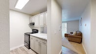 Located in Lynnwood, WA, this well-designed one-bedroom, one-bathroom unit offers a thoughtful layout across a single floor. The open living room is bright and inviting, featuring plush carpeting, a ceiling fan with light fixture, and a large sliding glass door fitted with vertical blinds that floods the space with natural light. The kitchen is a standout feature, designed in a galley style with light gray cabinetry, marble-look countertops, wood-look vinyl flooring, and black appliances including a range, dishwasher, and refrigerator. A pass-through opening connects the kitchen to the living area, enhancing the open feel of the home. The bedroom offers a comfortable, carpeted retreat with a window providing views of the surrounding area and ample natural light. Two closets provide generous storage throughout the unit. The bathroom is clean and functional, featuring a full tub-shower combination with a white surround. With a neutral color palette of warm whites and soft beiges throughout, the space maintains a cohesive, welcoming ambiance well-suited for comfortable everyday living.