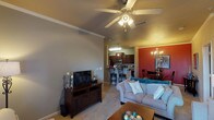 This 2-bedroom, 2-bathroom single-floor residence offers a comfortable and stylish layout designed for everyday living. The open-concept living area greets you with warm neutral tones, crown molding, and a ceiling fan with integrated lighting. A teal accent wall adds a pop of color, complementing the plush carpeting and creating an inviting atmosphere. The living space flows seamlessly into a dedicated dining area, distinguished by a bold red accent wall, crown molding, and an elegant chandelier overhead.

The kitchen is well-equipped with rich dark wood cabinetry, granite-style countertops, stainless steel appliances, and durable hardwood-style flooring. A breakfast bar with seating provides additional dining options and connects the kitchen to the main living space.

Both bedrooms are generously sized, featuring ceiling fans, plush carpeting, and walk-in closets. The primary bedroom includes a spacious closet and private access to one of the two full bathrooms. The second bedroom benefits from natural light through a large window and its own adjacent bathroom, each outfitted with a tub-shower combination.

Throughout the residence, a cohesive neutral palette with carefully chosen accent colors, crown molding details, and functional layouts create a space that is both practical and aesthetically appealing.