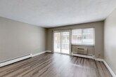Located at 200 Mountain Ave in Malden, MA, this 1-bedroom, 1-bathroom unit is thoughtfully laid out across a single floor. The interior features updated light-toned hardwood-style flooring throughout, complemented by neutral warm-gray walls and clean white trim and baseboards that create a bright, cohesive aesthetic.

The living area is generously sized, bathed in natural light from large sliding glass doors that open to a balcony with outdoor views. A wall-mounted HVAC unit and baseboard heating ensure year-round comfort. The space flows seamlessly from the living area into the rest of the unit.

The kitchen is a well-organized galley-style space outfitted with warm wood cabinetry, grey laminate countertops, a patterned tile backsplash, and white appliances including a gas range and refrigerator. A window and louvered closet doors add functionality to this compact yet efficient cooking area.

The bedroom offers a quiet retreat with a wide window for natural light, baseboard heating, and a full-width double louvered closet providing ample storage. An additional flexible room with recessed lighting and baseboard heat offers potential as a home office or den.

The bathroom is clean and simply appointed with a white vanity, tub/shower combination, and light wood-look flooring, maintaining the unit's consistent, tidy finish throughout.