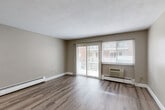 This 690 square foot one-bedroom apartment in Malden, MA offers a blend of modern updates and practical design. The living area is spacious and bright, featuring a large window that allows natural light to flood the room. Wood-look flooring runs throughout the apartment, adding warmth and durability.

The kitchen is efficiently designed with ample wooden cabinetry, providing plenty of storage space. It includes white appliances and a unique mosaic-style backsplash that adds visual interest. The countertops appear to be a light-colored material, possibly laminate or quartz.

The bedroom is generously sized with a large closet featuring louvered doors, offering ample storage space. The bathroom is clean and functional, with a white tub/shower combination, toilet, and vanity. 

The apartment also includes a separate dining area and what appears to be a small home office or den space. Baseboard heating units are visible in several rooms, ensuring comfort during colder months. The neutral color palette of beige walls and white trim creates a versatile backdrop for various decor styles.

Overall, this apartment offers a comfortable and modern living space, ideal for singles or couples seeking an updated urban dwelling in the Malden area.