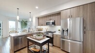 This thoughtfully laid-out one-bedroom, one-bathroom residence in San Diego, CA offers a cohesive coastal aesthetic defined by light wood flooring, crisp white walls, and natural textures throughout. The open-concept kitchen and living area serves as the heart of the home, where a sleek kitchen impresses with warm wood cabinetry, a white quartz waterfall island with an undermount sink, subway tile backsplash, and stainless steel appliances including a gas range. Pendant lighting and recessed fixtures illuminate the space effectively. The living area is bright and airy, benefiting from large windows that draw in natural light, creating a calm, inviting atmosphere. A private balcony extends the living space outdoors, accessible through a glass-paneled door. The bedroom is comfortably sized, featuring large sliding windows with outdoor views, soft carpeting, a barn-style closet door, and ample natural light. The bathroom continues the neutral palette with warm wood vanity cabinetry, a tub-shower combination with white tile surround, and light wood flooring. A hallway connects the rooms efficiently, completing this well-organized San Diego residence.