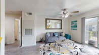 Located at 5555 Holly View Dr in Houston, TX, this one-bedroom, two-bathroom single-floor residence offers a well-organized and efficient layout with a bright, welcoming ambiance throughout. The living room serves as the heart of the home, featuring wood-look flooring, a ceiling fan with light fixture, and a sliding glass door that opens directly onto a private balcony, flooding the space with natural light and providing outdoor access. The galley-style kitchen is thoughtfully designed with rich warm-toned cabinetry, granite-look countertops, a full suite of black appliances, and ample storage. A pass-through counter with bar seating connects the kitchen to the dining area, creating an open and social flow between spaces. The bedroom is a comfortable and generously sized retreat, complete with plush carpet, a ceiling fan, large windows with blinds, and direct access to a well-appointed en-suite bathroom featuring a wide vanity with rich wood cabinetry and granite-look countertops. A spacious walk-in closet off the bedroom provides substantial storage with wire shelving. A second full bathroom serves the rest of the home. Three total closets ensure excellent storage capacity throughout this efficiently designed residence.
