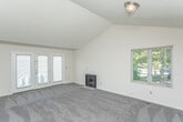 Located at 387 Rolling Meadows Dr in Ann Arbor, Michigan, this two-floor home offers a practical and well-organized layout across its levels. The kitchen is equipped with warm oak cabinetry, white appliances including a gas range, dishwasher, and refrigerator, complemented by light wood-style flooring and a double-basin sink beneath a window with views of the surrounding greenery. The kitchen connects openly to adjacent living areas, allowing for easy flow throughout the main level. Carpeted rooms feature windows dressed with horizontal blinds, inviting natural light and outdoor views of the lush yard. One room showcases vaulted ceilings, adding a sense of spaciousness and volume. The bathrooms are finished with light wood-style vinyl flooring, white vanity cabinetry with ample drawer storage, a tub-shower combo with chrome fixtures, and towel bars. An attached single-car garage with an automatic opener provides convenient interior access. The unfinished basement spans a generous footprint with concrete floors, exposed wood-beam ceilings, visible ductwork, and utility systems including a furnace and water heater — offering significant potential for future finishing or use as storage and utility space. Small basement windows allow for minimal natural light below grade.