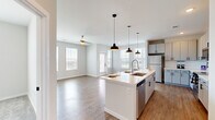 Located in the sought-after Grand Cordera neighborhood of Colorado Springs, CO, this well-designed single-floor home offers three bedrooms and two bathrooms across a comfortable and efficiently laid-out floor plan. The entrance leads through a bright, clean hallway accented by arched doorways and warm hardwood-style flooring, guiding you into the heart of the home. The open-concept kitchen and living area is a standout feature, boasting a central island with a undermount sink, sleek white cabinetry, stainless steel appliances, and stylish pendant lighting. Multiple windows bathe the space in natural light, while a ceiling fan adds comfort to the living area, which also offers access to the outdoors. The bedrooms are carpeted for warmth and comfort, each equipped with a ceiling fan and windows with views of the surrounding neighborhood. The spacious primary bedroom connects to an en-suite bathroom featuring marble-style tile in a glass-enclosed shower, a white vanity, and direct access to a walk-in closet with built-in shelving. The secondary bathroom includes a full tub and shower with elegant marble-style tile surround. Additional closets and hallways complete this clean, modern home.