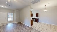 This single-story, 3-bedroom, 2-bathroom home offers a well-designed layout with a comfortable flow throughout. The open living room is a standout space, featuring wood-look laminate flooring, a ceiling fan, a classic white fireplace, and a front-facing window that allows natural light to fill the room. The kitchen is functional and stylish, outfitted with rich dark-brown cabinetry, light countertops, tile flooring, a stainless steel sink, and a pendant light over the dining area, which connects seamlessly to the living space. The three bedrooms are bright and well-proportioned, with wood-look flooring and windows that bring in natural light. Three closets provide ample storage throughout the home, including a generously sized walk-in closet with built-in shelving and hanging rods. The two bathrooms are finished with tile flooring, dark-brown vanity cabinetry, and light countertops; one features a full tub-shower combination. A dedicated laundry room includes overhead cabinetry and connections for both electric and gas appliances. The attached garage offers additional utility and storage space. The home presents a clean, neutral palette throughout, creating a practical and comfortable living environment.