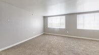 Located at 1002 Kennebec St in Oxon Hill, MD, this single-floor residence offers two bedrooms, two bathrooms, and a thoughtfully arranged layout designed for comfortable everyday living. The entrance leads into a combined living and dining area featuring plush carpeting, neutral gray walls, and multiple windows fitted with blinds that allow for ample natural light. A ceiling fan adds both style and functionality to the living space, which also includes a wall-mounted HVAC unit for year-round climate control. The kitchen is efficiently designed with a galley-style configuration, featuring dark espresso cabinetry, granite-look countertops, tile flooring, and a full suite of black appliances including a gas range, dishwasher, and refrigerator. The primary bedroom is generously proportioned, carpeted, and includes two side-by-side closets offering abundant storage. The second bedroom is similarly finished with carpet flooring, a large window, and its own wall HVAC unit. Four closets are distributed throughout the unit, providing excellent storage capacity. Both bathrooms are clean and functional, with one featuring a full tub-shower combination with white tile surround. The overall aesthetic is understated and neutral, offering a move-in ready canvas throughout.