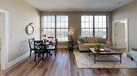This 2-bedroom, 2-bathroom single-floor residence offers a thoughtfully designed layout with a seamless flow between living, dining, and kitchen areas. The open-concept living and dining space is anchored by large multi-pane windows that flood the room with natural light and frame sweeping outdoor views, creating a bright and airy atmosphere. Rich hardwood-style flooring runs throughout the main living areas, complementing the neutral warm-toned walls.

The kitchen is well-equipped with white raised-panel cabinetry, granite countertops, and a full suite of stainless steel appliances, including a range, over-the-range microwave, and French door refrigerator. Hardwood-style flooring continues seamlessly into this space.

Both bedrooms are comfortably sized and carpeted, offering a quiet retreat. The primary bedroom features a large window with expansive outdoor views, while the second bedroom includes a closet and ample space. Each bathroom is finished with granite-topped white vanities, hardwood-style flooring, and tub/shower combinations, providing a clean and polished aesthetic throughout. The overall ambiance is warm, modern, and inviting.