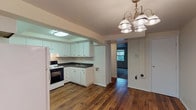 Located on Pennswood Drive in Huber Heights, Ohio, this two-floor home offers a well-organized layout designed for comfortable everyday living. The main level welcomes you through a front entry with an arched transom window, opening into a living area that features rich hardwood flooring and a staircase with decorative wrought-iron railings leading to the upper level. An elegant chandelier illuminates the dining area, which flows directly into a functional kitchen. The kitchen is appointed with white cabinetry, dark granite-style countertops, a tile backsplash, a white electric range, and a full-size refrigerator, with a skylight adding a touch of natural brightness to the space. Upstairs, the carpeted bedrooms provide a comfortable retreat, with windows that bring in natural light and views of the surrounding neighborhood. One bedroom features a spacious layout with ample closet space, including bifold doors for easy access. The full bathroom is outfitted with a clean white tub-shower combination with built-in shelving. Throughout the home, neutral tones and straightforward finishes create a move-in ready environment suited to a variety of living arrangements.
