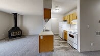 This one-bedroom, one-bathroom apartment at 513 E. Marion Rd. in Wichita, KS offers a practical and efficiently designed single-floor layout. The open-concept kitchen serves as a central hub of the unit, featuring warm oak-toned cabinetry — both upper and lower — a built-in range hood, white appliances including a refrigerator and electric range, and a peninsula with an integrated sink and light countertops. The peninsula separates the kitchen from the carpeted living area, creating a natural flow between the two spaces. A dedicated pantry provides additional storage convenience. The bedroom is a comfortable, well-proportioned room with soft carpeting, neutral wall tones, a window that allows natural light, and two side-by-side closets offering ample storage. A textured ceiling is consistent throughout the unit. The full bathroom includes a combined tub and shower unit, a toilet, a wood-toned vanity with sink, and wood-look tile flooring. Overall, the apartment presents a clean, functional design with consistent warm wood accents, neutral color palettes, and practical finishes suited for everyday living.