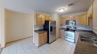 This single-floor unit offers a practical and straightforward layout designed for comfortable everyday living. The kitchen is well-equipped with light oak cabinetry providing ample storage, dark granite-style countertops, and a full suite of stainless steel appliances including a refrigerator with ice maker, electric range, microwave, and dishwasher. Light ceramic tile flooring and a textured ceiling complete the functional space.

The bedrooms are carpeted and finished with warm oak trim and baseboards. Several rooms include built-in closets with oak-framed sliding doors and hanging rods, offering practical storage solutions. Select bedrooms feature windows with outdoor views of the surrounding landscape, allowing natural light to brighten the space.

Two full bathrooms serve the unit, each finished with light ceramic tile flooring, neutral beige walls, and oak vanities with white countertops. One bathroom features a standalone walk-in shower with a chrome-framed frosted glass sliding door, while the second offers a shower-tub combination with a matching frosted glass enclosure. Both bathrooms include grab bars for added convenience and safety throughout.
