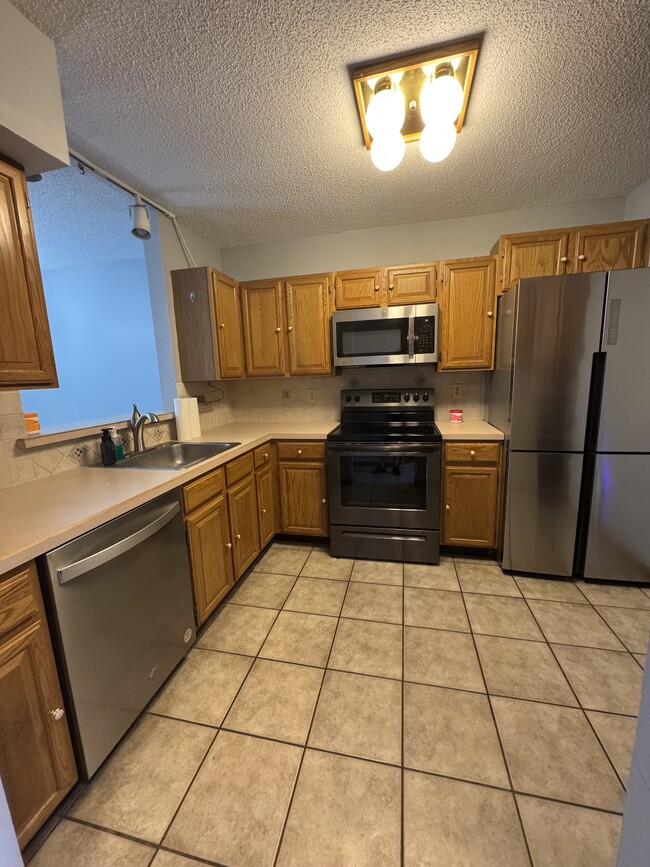 Kitchen features modern fridge/freezer, new dishwasher, glass cooktop, all stainless steel - 705 Lake Ave