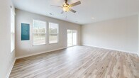 This two-story home in Suffolk, Virginia offers a well-organized layout across two floors. The main level features an open-concept kitchen and living room filled with natural light from multiple windows and a sliding glass door. The living area is finished with light hardwood flooring and a ceiling fan overhead. The kitchen is appointed with white shaker cabinetry, granite countertops, stainless steel appliances, and recessed lighting, creating a clean, modern aesthetic. A half bathroom and access to the attached garage round out the main floor. The garage features drywall-finished walls and a concrete floor. Upstairs, the primary bedroom is generously sized with an en-suite bathroom showcasing granite countertops, white cabinetry, a walk-in shower, and a soaking tub. Two additional bedrooms are bright and well-proportioned, each with light hardwood floors and windows offering outdoor views. A dedicated laundry room with a full-size washer and dryer adds everyday convenience. Throughout the home, a neutral color palette, clean white trim, and consistent hardwood-style flooring create a cohesive and move-in-ready atmosphere.