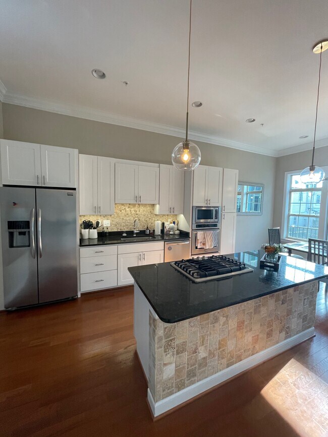 Kitchen Side 1 with stainless steel appliances, gas stove top, large island and extra storage space - 127 W Fort Ave