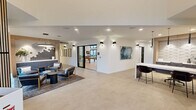 Located at 6021 Lakewood Dr W in University Place, WA, this thoughtfully designed single-floor community amenity facility offers a comprehensive range of spaces for residents to gather, relax, and stay active. The welcoming lobby greets visitors with large-format stone-look tile flooring, recessed and wall-mounted lighting, curated artwork, and a sleek reception counter — setting a polished, modern tone throughout.

The open lounge area flows seamlessly into a dedicated game room, which features a full-size pool table, shuffleboard table, and additional game surfaces beneath a striking slatted wood ceiling detail and modern pendant lighting. Sliding glass doors connect this space directly to an outdoor terrace, flooding the interior with natural light.

A standout great room showcases a dramatic floor-to-ceiling wood-clad fireplace wall with a mounted display, flanked by expansive black-framed glass walls and sliding doors that open to the outdoors, creating a bright and airy atmosphere.

The well-equipped fitness center is lined with large windows overlooking lush greenery, housing both strength and cardio equipment. Additional spaces include a private office area with a textured 3D tile accent wall, custom cabinetry, and materials display, as well as a utility/storage room. A connecting hallway ties all areas together, ensuring smooth circulation throughout this versatile and amenity-rich facility.