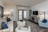This single-floor residence at 200 Citygreen Way in Chattanooga, Tennessee offers a thoughtfully designed layout with a cohesive blend of modern finishes and comfortable living spaces. The entryway features wood-look flooring that extends throughout the main areas, crisp white walls, and decorative framing that creates a welcoming first impression as it leads into the heart of the home. The living room is bright and open, anchored by neutral tones and offering ample space for relaxed gatherings. The kitchen is well-equipped with rich dark cabinetry, light countertops, and black appliances, complemented by a dedicated pantry with wire shelving for generous storage. A conveniently located in-unit laundry room with full-size washer and dryer connections adds everyday practicality. Both bedrooms are carpeted and feature ceiling fans, large windows that invite natural light, and a calm, restful ambiance. The bathroom is finished with dark vanity cabinetry, a single-sink vanity with a large mirror, and a tub-shower combination. Throughout the residence, the consistent use of wood-look flooring, neutral color palettes, and thoughtful storage solutions create a functional yet stylish living environment in the heart of Chattanooga.