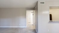 Located at 8917 S Gessner Rd in Houston, TX, this single-floor, one-bedroom, one-bathroom unit offers a thoughtfully organized layout across a compact but functional footprint. Light-toned ceramic tile flooring runs consistently throughout the space, lending a clean and cohesive look.

The living room is bright and welcoming, featuring a ceiling fan with light fixture and a large sliding glass door dressed with vertical blinds that allows natural light to pour in and provides direct access to the outdoors. Adjacent to the living room, the dining area is accented by an elegant multi-bulb chandelier and connects to the kitchen through a pass-through window with a granite countertop ledge.

The galley-style kitchen is efficiently designed with gray cabinetry, granite countertops, a marble-style tile backsplash, a sink, and black appliances including a refrigerator and range. A pantry provides additional storage just off the kitchen.

The bedroom is generously proportioned with a ceiling fan and is supported by two closets, one of which features built-in shelving and hanging rods for organized storage. The bathroom includes a soaking tub with a striking marble-style tile surround, a toilet, and tile flooring. A hallway connects the main living areas to the private spaces, completing this well-planned unit.