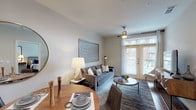This single-floor, 1-bedroom, 1-bathroom residence is designed with a modern aesthetic and a functional open-concept layout. The living area features warm hardwood-style flooring, neutral toned walls, and a set of full-length French doors that flood the space with natural light and provide access to an outdoor area. A dedicated dining space flows seamlessly into the living room, creating an inviting area for both relaxing and entertaining.

The kitchen is a standout feature, outfitted with rich dark cabinetry that reaches toward the ceiling, a full suite of stainless steel appliances including a French door refrigerator, electric range, built-in microwave, and dishwasher. Light countertops and a stainless steel island provide ample prep and dining space, complemented by hardwood-style flooring that continues throughout.

The bedroom is a comfortable retreat, featuring plush carpeting, a ceiling fan, and its own set of French doors offering additional natural light and outdoor access. The full bathroom is finished with tile flooring and connects conveniently to the bedroom.

An entry foyer with a louvered closet door provides practical storage near the front entrance. Throughout the residence, recessed and pendant lighting enhance the clean, contemporary ambiance, making this a thoughtfully designed and highly livable home.