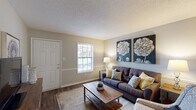 Located at 1515 S Mebane St in Burlington, North Carolina, this single-floor residence offers a thoughtfully designed layout that balances comfort and functionality. The living room serves as the heart of the home, featuring warm wood-look flooring, a textured ceiling, and a chair rail accent along neutral-toned walls. Natural light filters in through a window near the front entry door, creating a bright and welcoming atmosphere. The kitchen is outfitted with crisp white cabinetry accented by matte black hardware, light countertops, a double stainless steel sink, and black appliances, including a range — a clean, classic combination that is both practical and visually appealing. The bedroom is a restful retreat, carpeted for comfort and equipped with a ceiling fan with light fixture. A window allows for natural light, and the room offers ample space for a full furniture arrangement. The bathroom features wood-look flooring consistent with the rest of the home, a shower-tub combination, a vanity with countertop space, and neutral wall tones that contribute to a calm, functional environment. Throughout the residence, consistent finishes and a cohesive neutral color palette create a unified, move-in ready living space.