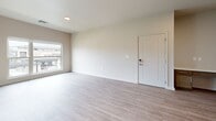 Located at 4007 N Ridge Rd in Wichita, Kansas, this well-appointed one-bedroom, one-bathroom unit offers a thoughtfully designed open-concept layout across a single floor. Light wood-tone vinyl plank flooring flows through the living and kitchen areas, complementing the bright, neutral color palette throughout the space.

The kitchen is a standout feature, boasting rich medium-toned wood cabinetry, crisp white quartz countertops, a subway tile backsplash, and a large center island with an undermount sink. Stainless steel appliances, including a refrigerator and dishwasher, are paired with a black electric range and microwave. Stylish pendant lighting and a sliding glass door that fills the space with natural light complete the kitchen's modern aesthetic.

The living room offers generous open space with light vinyl plank flooring and a large window that brings in ample natural light. The bedroom features plush wall-to-wall carpet, a ceiling fan, and a sizable window with outdoor views, creating a comfortable and serene retreat.

The bathroom is finished with a wood-toned vanity, white quartz countertop, a large mirror, and a walk-in shower. The unit also includes a dedicated closet and a convenient in-unit laundry area, rounding out this efficiently designed and modern living space.