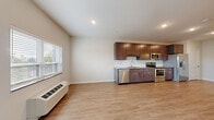 Located at 13650 Marsh View Boulevard in Rogers, MN, this thoughtfully designed one-bedroom, one-bathroom unit offers an efficient and modern living experience across a single floor. The open-concept layout seamlessly connects the kitchen and living room, creating a bright and functional shared space. Light-toned luxury vinyl plank flooring runs throughout, complementing the neutral wall palette and lending a clean, cohesive aesthetic.

The kitchen is a standout feature, outfitted with rich dark-espresso cabinetry extending to the ceiling for ample storage, granite countertops, a classic white subway tile backsplash, and a full suite of stainless steel appliances including a refrigerator with ice maker, electric range, built-in microwave, and dishwasher. The living area benefits from a sliding glass door that opens to a balcony, allowing natural light to fill the space.

The bedroom is a comfortable retreat with two closets providing generous storage. The bathroom features matching dark cabinetry with granite countertops and a full tub-shower combination. A dedicated in-unit laundry area adds everyday convenience. Recessed lighting throughout and a wall-mounted HVAC unit complete this well-equipped, move-in-ready home.