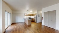 Located at 488 NE Bellevue Dr in Bend, Oregon, this well-designed one-bedroom, one-bathroom unit offers a thoughtful layout that maximizes everyday functionality. The open-concept living and kitchen area forms the heart of the space, featuring warm hardwood-style flooring that flows throughout. The kitchen is outfitted with stainless steel appliances—including a refrigerator, electric range, and range hood—complemented by granite countertops, warm wood cabinetry, a white tile backsplash, and a peninsula island with a sink and pendant lighting above. The living area is bright and airy, with large windows fitted with blinds that allow natural light to fill the room, and a sliding glass door that opens to a private balcony. The bedroom is carpeted for comfort and includes a built-in closet, ceiling fan, and a sizable window with outdoor views. An additional closet provides extra storage. The bathroom features a clean, full-size soaking tub and shower combo. Completing the unit is an in-unit laundry area, adding everyday convenience. The overall aesthetic is clean and contemporary, with neutral tones and modern finishes throughout.