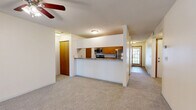 Located at 3456 Lake Shore Drive in Chaska, MN, this single-floor, 2-bedroom, 3-bathroom home offers a practical and comfortable layout. The open-concept living and kitchen area serves as the heart of the home, where a peninsula-style kitchen showcases warm wood cabinetry, granite-style countertops, stainless steel appliances including a range, microwave, and refrigerator, and durable hardwood-style flooring. A dedicated pantry provides additional storage. The living room is generously sized, featuring plush carpeting, a ceiling fan with light fixture, and a sliding glass door that fills the space with natural light and offers views of the surrounding greenery. Both bedrooms are well-proportioned with carpet flooring, and the primary bedroom offers ample square footage. Storage is a standout feature throughout, with six closets including wire-rack systems for organization. The three bathrooms include tile flooring and wood-accented vanities. A dedicated laundry room and utility room add further convenience. The attached garage includes an automatic opener and a built-in shelving ledge. A central hallway with tile flooring connects the main living areas, creating a cohesive and functional flow throughout the home.
