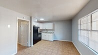 Located at 1619 Lake Ave in Tallahassee, Florida, this single-floor unit offers a straightforward and functional layout designed for comfortable everyday living. Throughout the space, warm-toned tile flooring provides a cohesive look that is both durable and easy to maintain, complemented by light gray walls that lend a clean, neutral backdrop.

The open-concept living area is filled with natural light streaming through a large window fitted with horizontal blinds, and features a ceiling fan with an integrated light fixture, promoting year-round comfort. A front entry door opens directly into this welcoming space.

The kitchen is efficiently arranged and well-equipped, featuring crisp white cabinetry that extends to the upper walls for ample storage, granite-patterned countertops, a stainless steel double-basin sink with a modern gooseneck faucet, a black electric range with an overhead exhaust hood, and a full-size black refrigerator. The kitchen flows seamlessly into the main living area, making it ideal for both daily use and entertaining.

The bedroom is a quiet, comfortable space also finished with tile flooring and a ceiling fan with a light fixture overhead, ensuring consistent airflow and lighting.

The bathroom is clean and functional, outfitted with a full-size soaking tub and shower combination featuring bright white surround walls, a toilet, and a vanity with storage below. The overall design of this unit prioritizes practicality and ease of living.